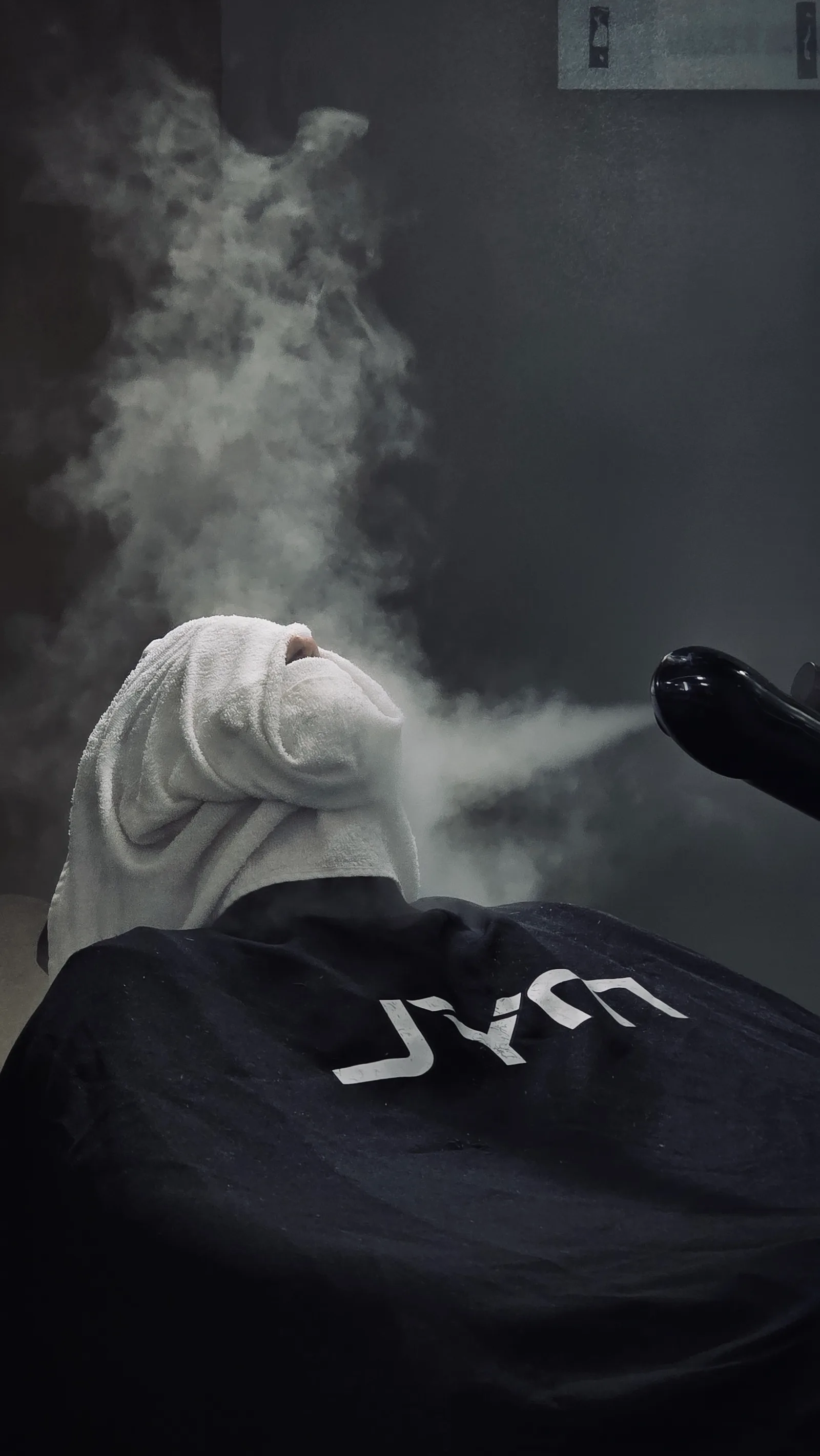 Toalha quente com vapor durante atendimento na MYL Barber Clinic