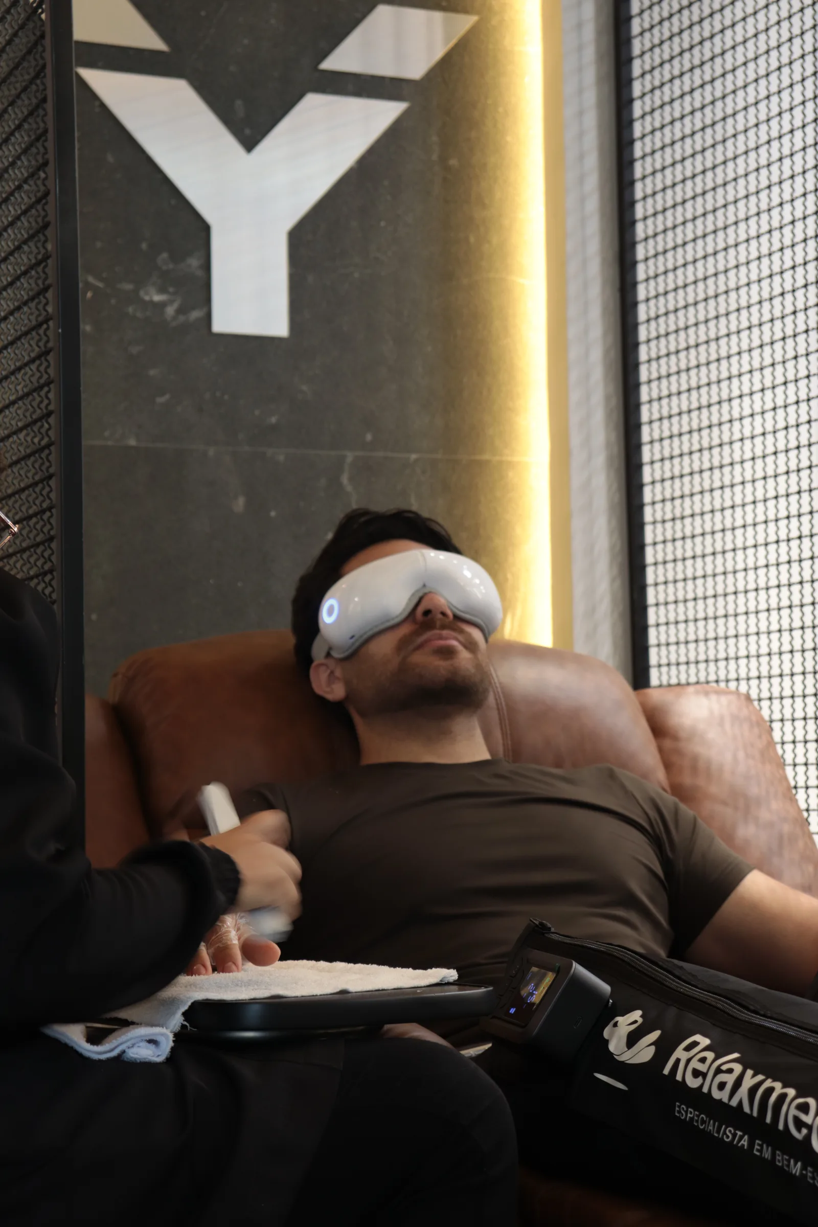 Cliente relaxando com máscara de massagem ocular na MYL Barber Clinic