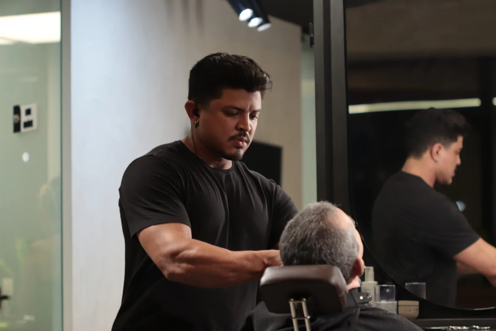 Barbeiro finalizando corte masculino em cliente na MYL Barber Clinic