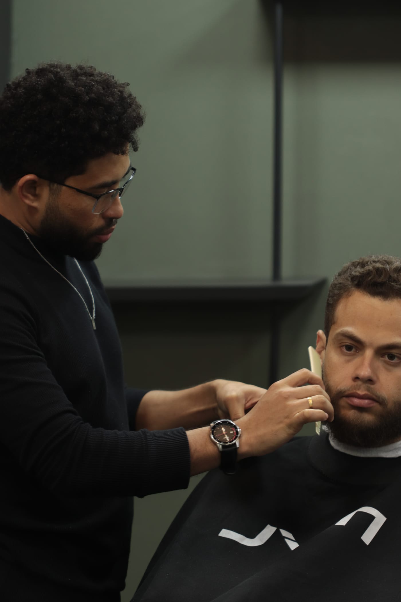 Barbeiro MYL aparando a barba de um cliente
