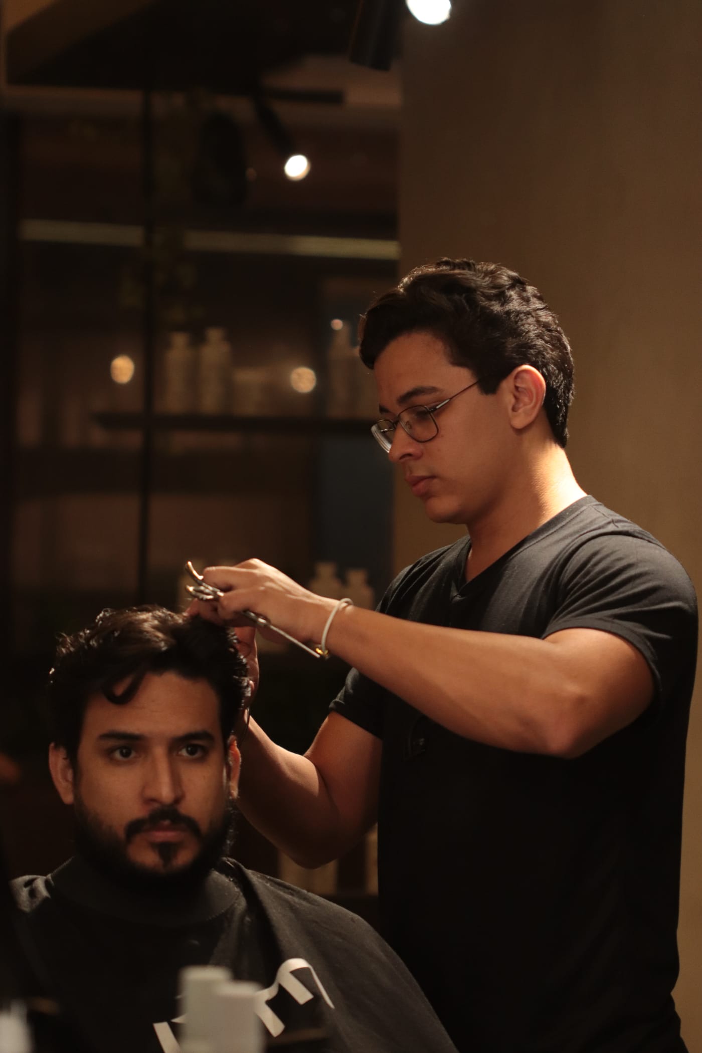 Barbeiro cortando o cabelo de um cliente com tesoura